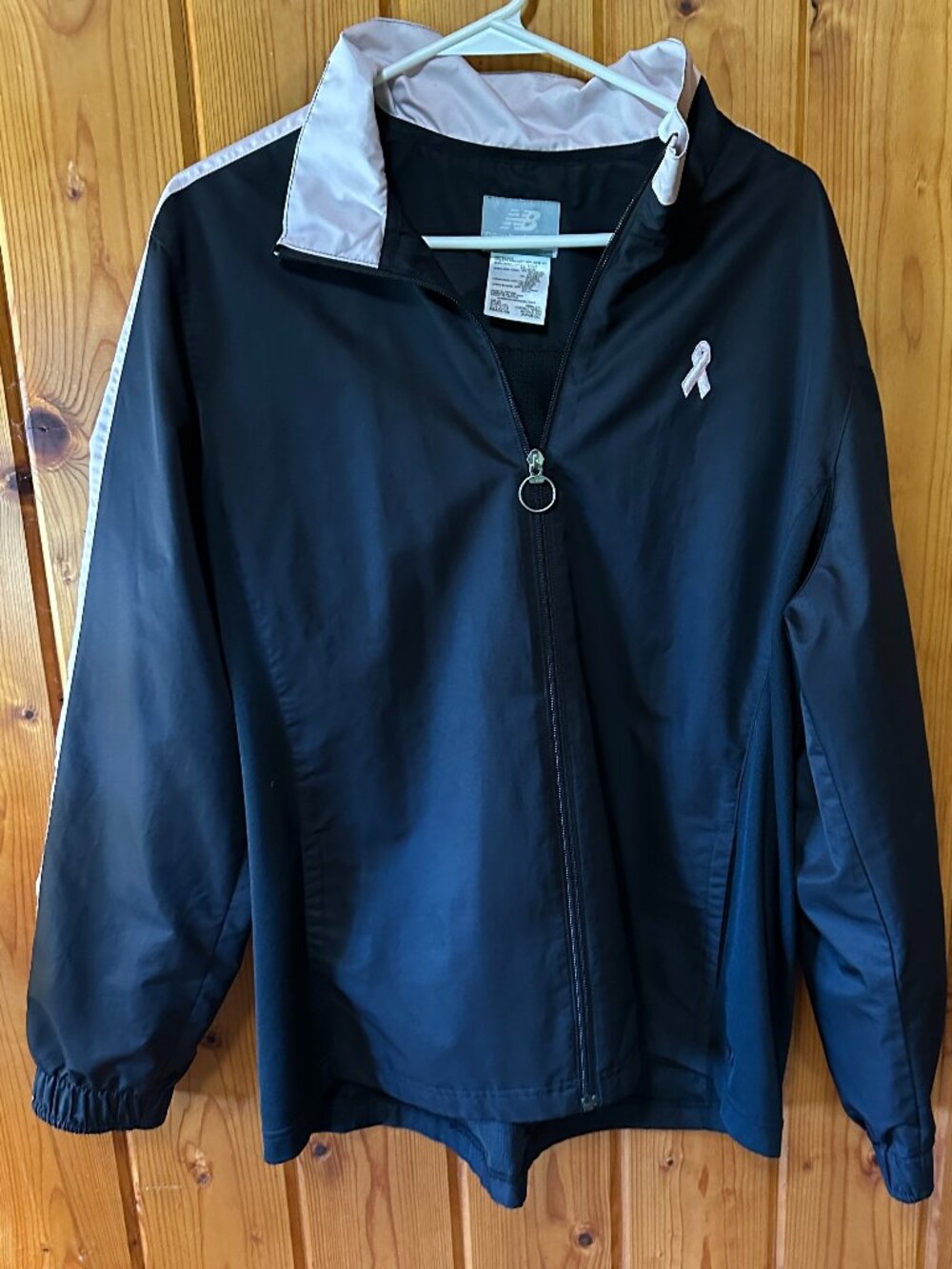 New Balance Women's XL Windbreaker Jacket in pink with a ribbon